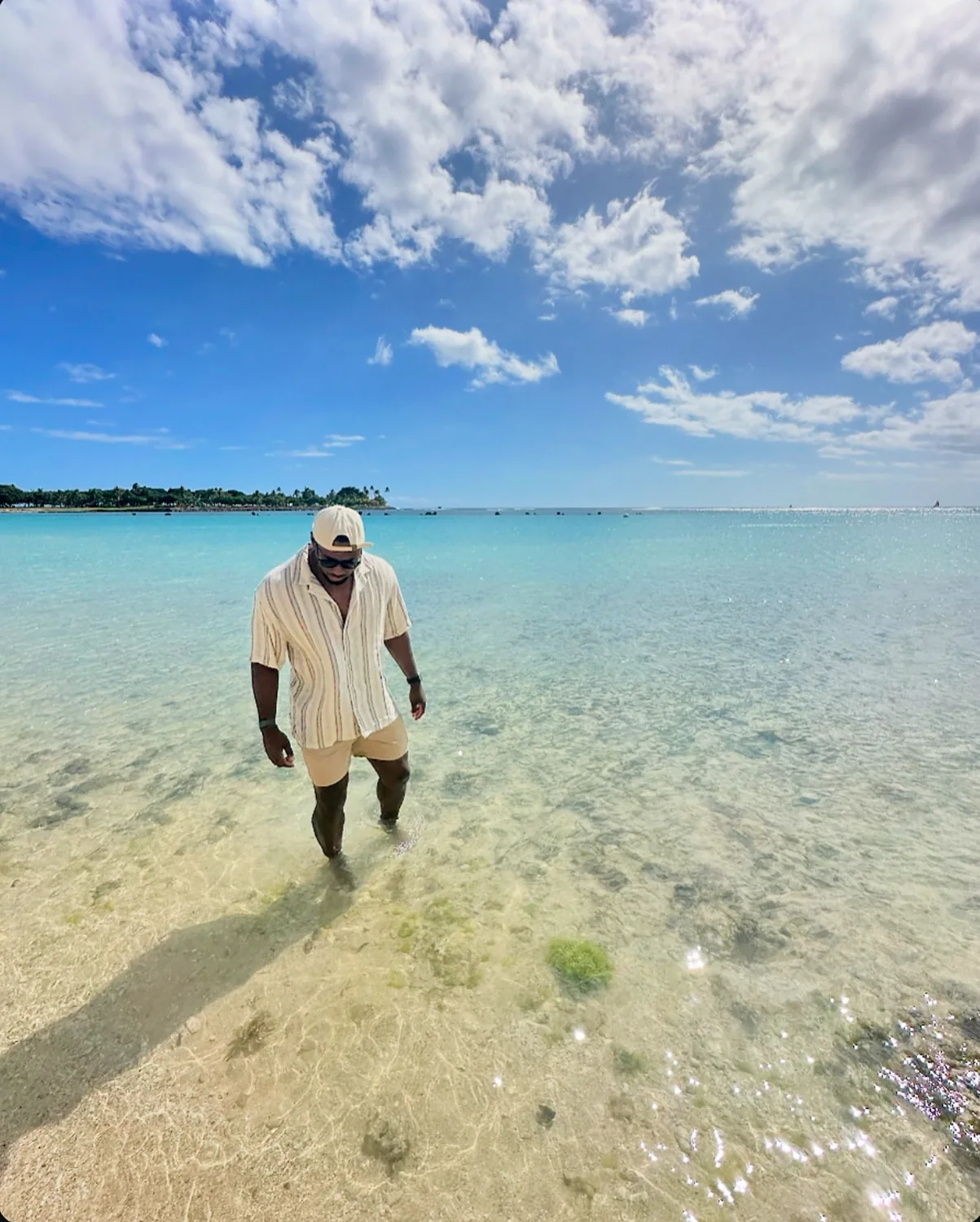 Mon Moore standing in clear turquoise water under an open sky
